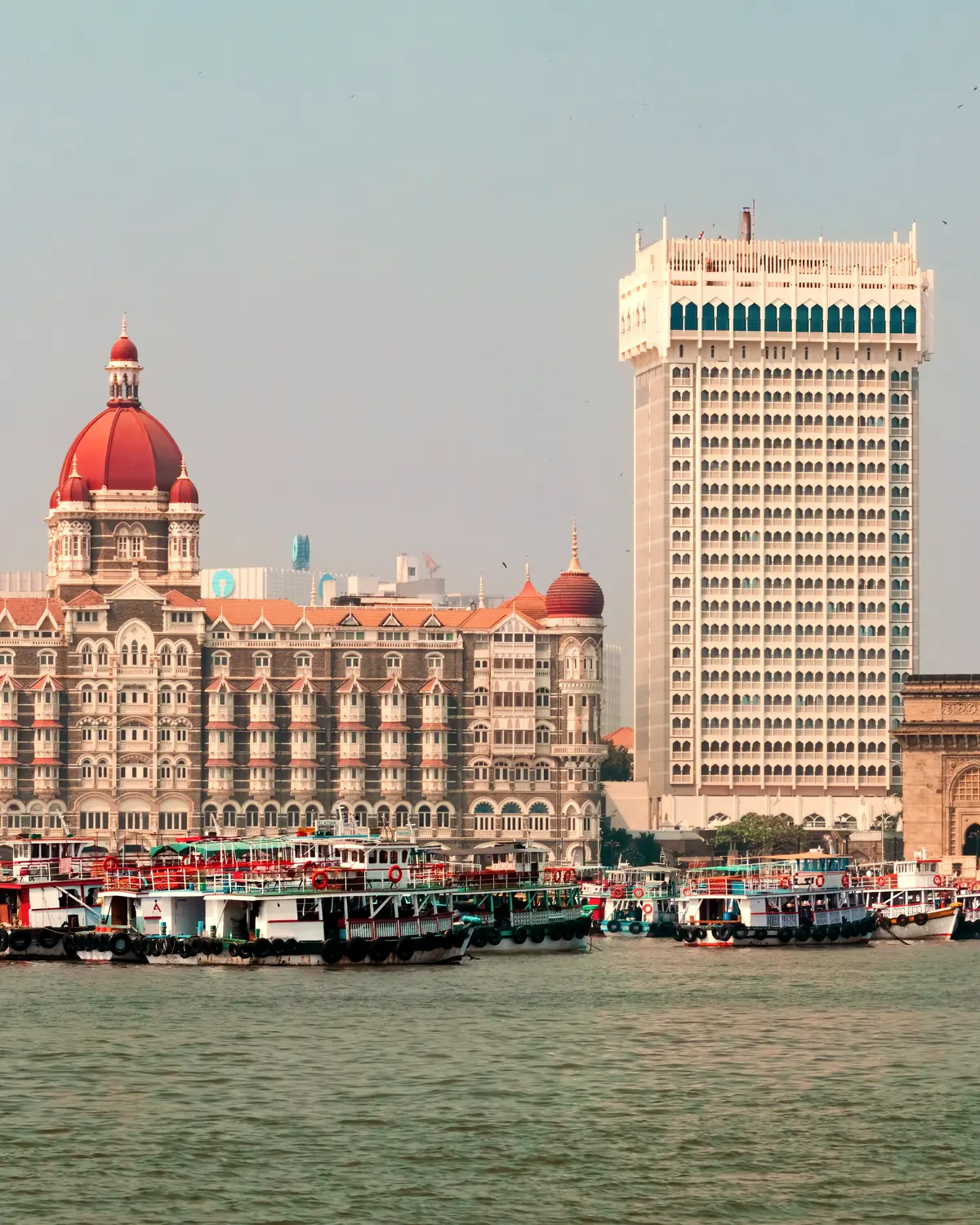 Panoramic view of Taj Palace Hotel and Taj Tower with the iconic Gateway of India in the background, overlooking the Arabian Sea in Mumbai