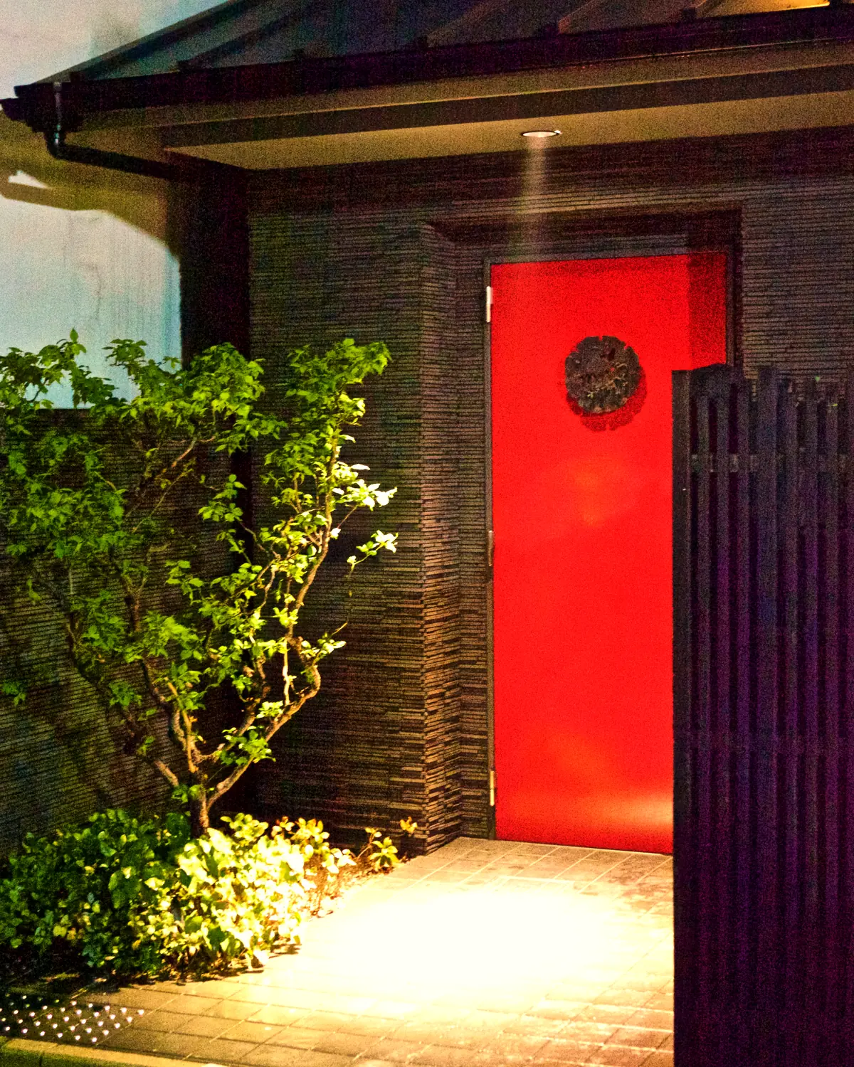 The red entrance door of Hotel Mume in Gion at night