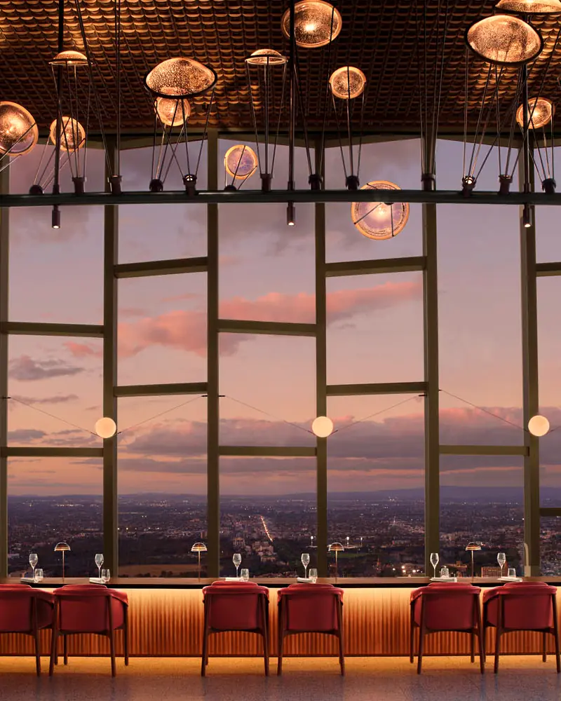 Atria Bar at The Ritz-Carlton, Melbourne: red stools at a long bar under hanging glass lights, looking over the city at dusk