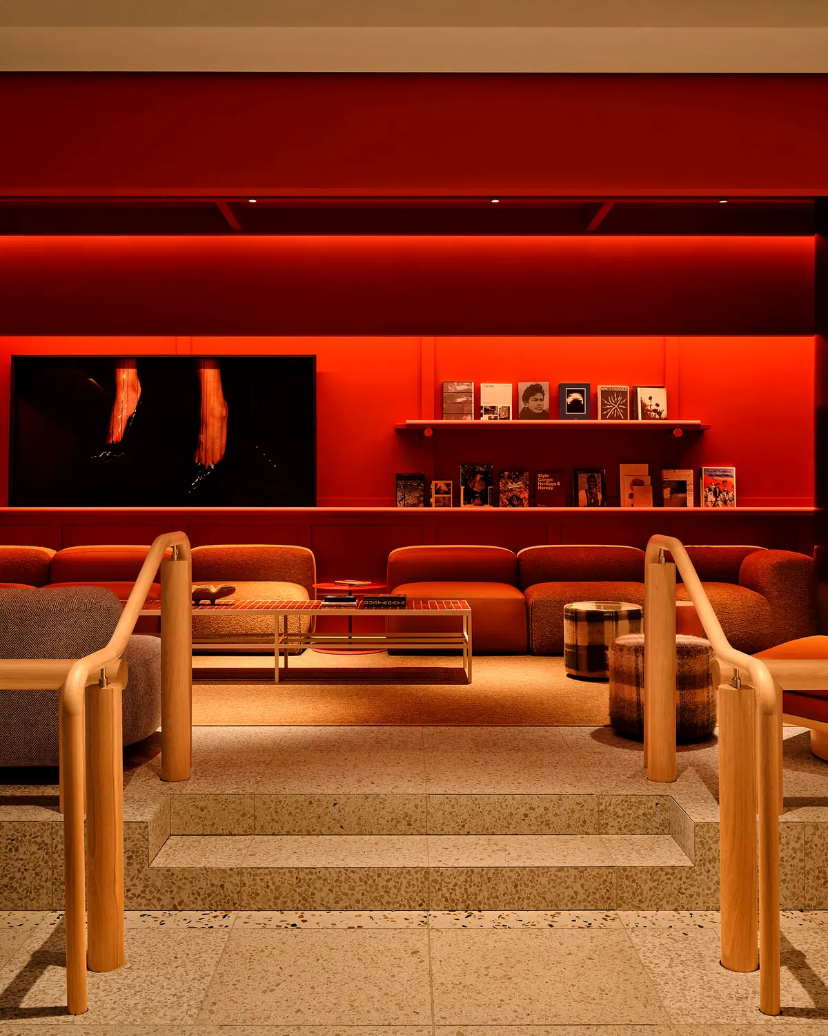 The lobby lounge at The StandardX, Melbourne: a red room with low sofas, seen through timber rails