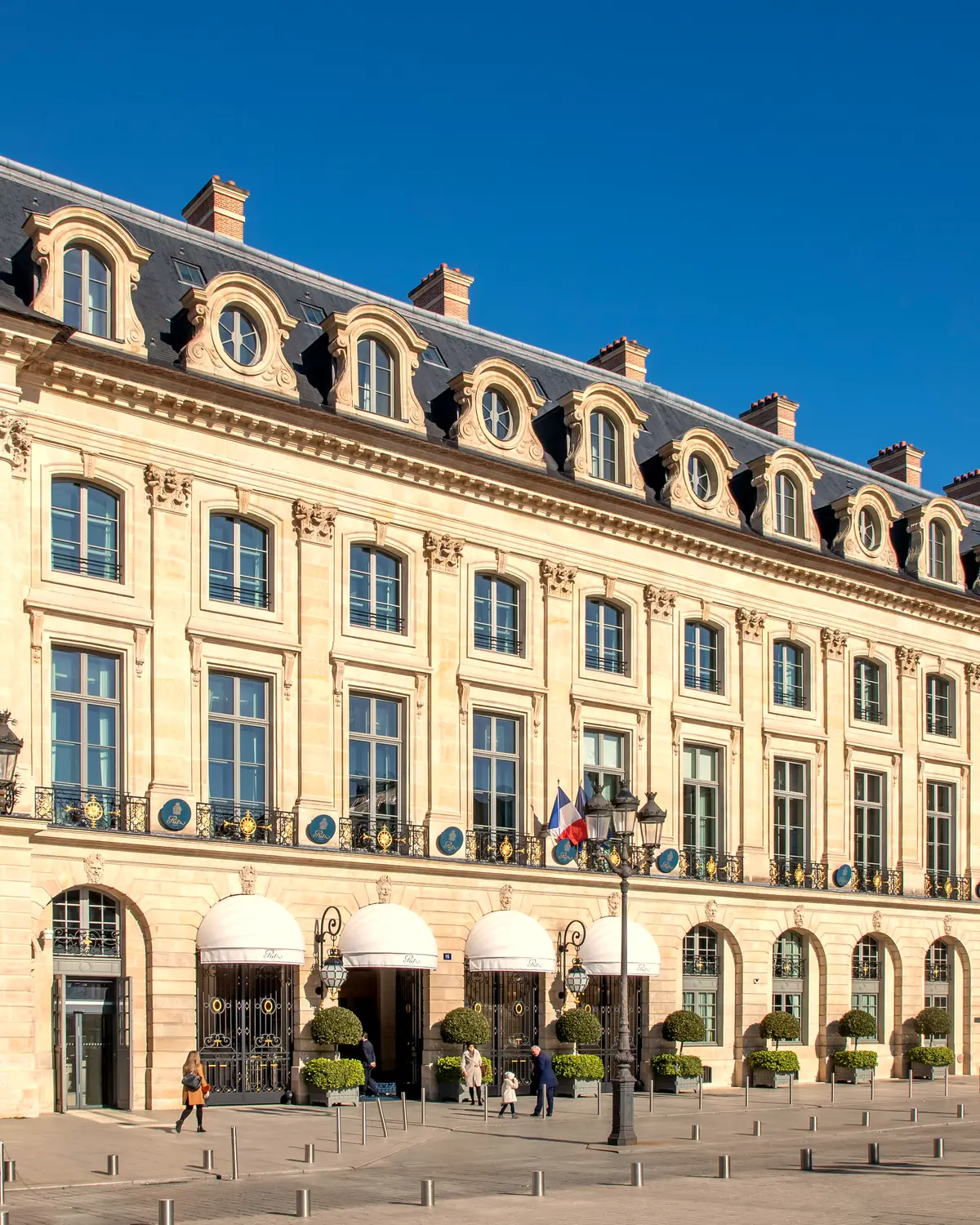Exterior: the hotel's frontage on Place Vendôme with white entrance awnings and planters (2022). Ritz Paris