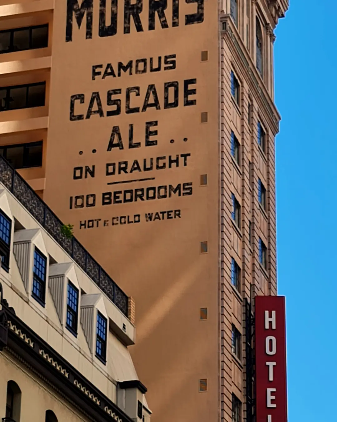 Painted side wall of the hotel lettered HOTEL MORRIS FAMOUS CASCADE ALE, with a vertical red HOTEL MORRIS sign