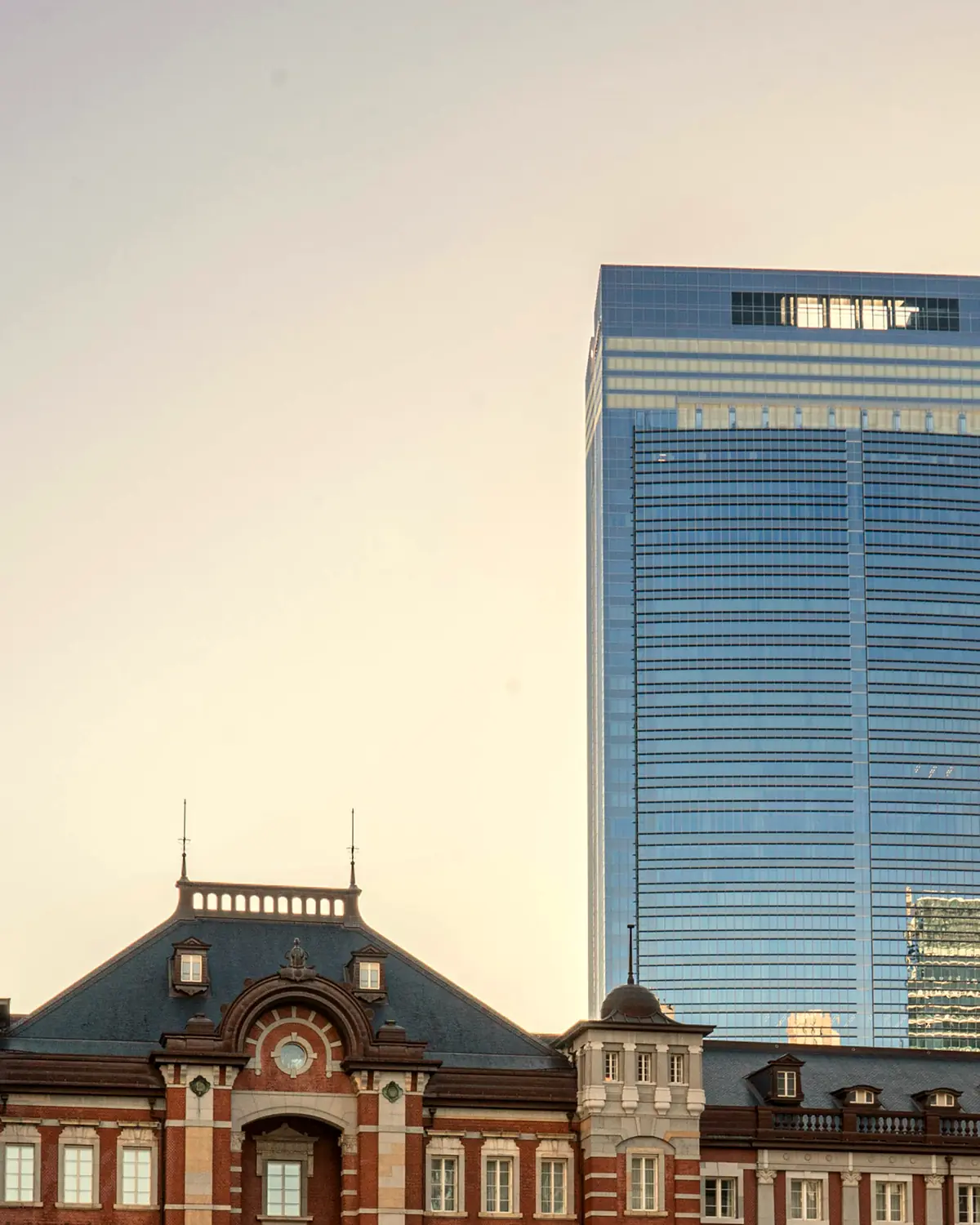 Tokyo Midtown Yaesu, whose upper floors hold the hotel, rising behind the red-brick roofline of Tokyo Station