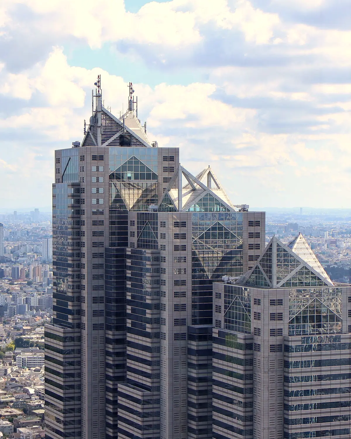 Shinjuku Park Tower, which houses the hotel on floors 39-52, with its stepped glass-pyramid tops (release caption: パーク ハイアット 東京)